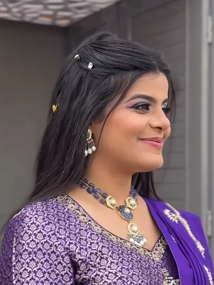 A side profile showing the half-up, half-down hairstyle with delicate accessories, perfect for a Haldi function.