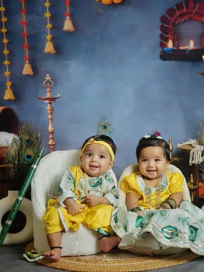 Twin brother and sister dressed as Krishna and Radha for a Janmashtami photoshoot. Their coordinated outfits and happy smiles are absolutely precious.