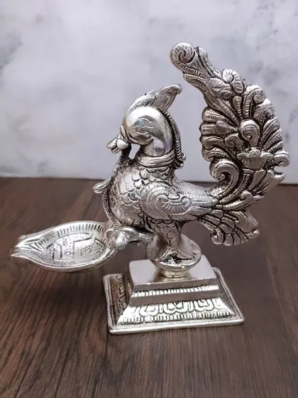 An antique German silver peacock diya with a square base, showcasing a unique and royal design.