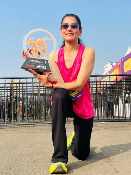 Dr. Indu proudly displays her winner's trophy from the Maha Marathon 10 km race. This is the kind of success that fuels our entire team's motivation.