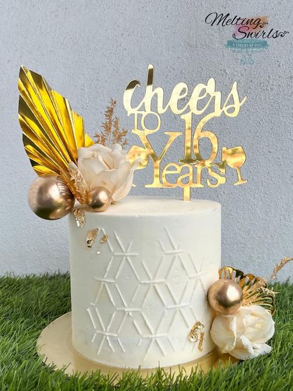 A chic white and gold buttercream cake with a geometric stencil design. This cake is perfect for an elegant anniversary or milestone birthday celebration.