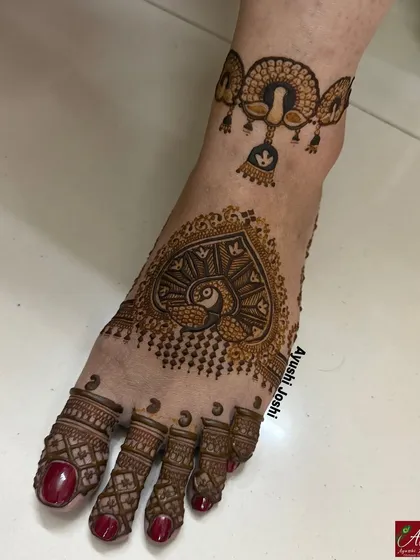 Your feet deserve beautiful art too. This is a minimal yet intricate bridal foot mehendi, featuring a peacock heart design and a delicate payal (anklet) band.