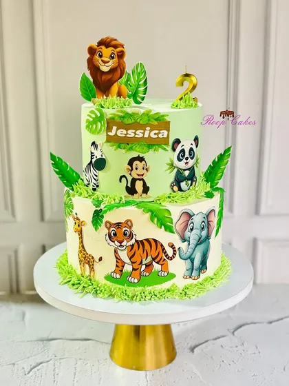 A wild jungle celebration for a sweet second birthday. This two-tier cake is filled with adorable safari animals like a lion, tiger, elephant, and panda.