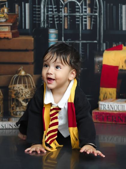Looking up in wonder, this little one seems to be spotting a golden snitch. It's a candid moment captured during our enchanting Harry Potter session.