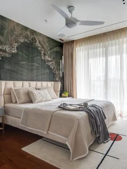 In this master bedroom, I wanted to create a dramatic yet calming focal point. I achieved this with a custom back wall featuring a striking green marble pattern set against handmade flutes. Paired with rich wooden flooring and soft, layered textiles, the room becomes a personal sanctuary that feels both luxurious and deeply restorative.