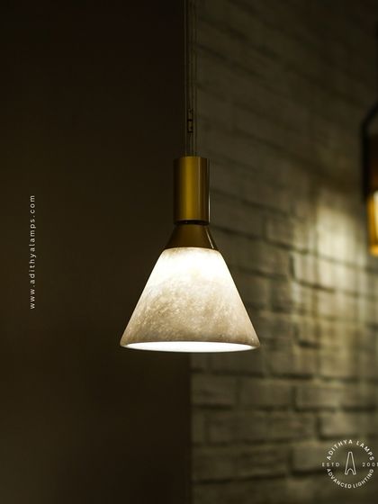 A close-up of the pendant light reveals the beautiful texture of the shade against a brick wall. This demonstrates how our fixtures can complement various interior materials, from rustic to modern.