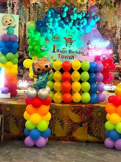 The Cocomelon stage is all lit up and ready for the party! The combination of colorful balloons, character cutouts, and lighting creates a high-energy, fun-filled backdrop.