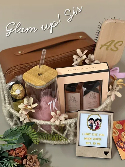 Glam up, sis! This Rakhi hamper is for the sister who loves to feel pampered. It includes a personalized brush, a glass tumbler, a fragrance set, and a funny photo frame, all arranged in a beautiful woven basket.