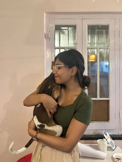 A participant closes her eyes and enjoys a peaceful hug with a beagle puppy.