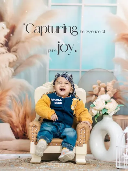 This little boy's laughter is infectious in his first birthday studio portrait. The warm, earthy tones of the boho-chic setup complement his bright and happy energy.