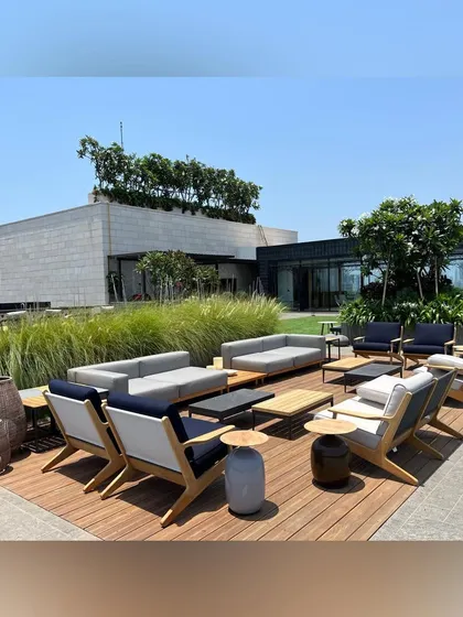 This rooftop lounge in Mumbai was designed as a luxurious escape with panoramic city views. The space features a custom wooden deck, comfortable outdoor sofas, and carefully selected ornamental grasses, creating a perfect setting for relaxation and social gatherings.