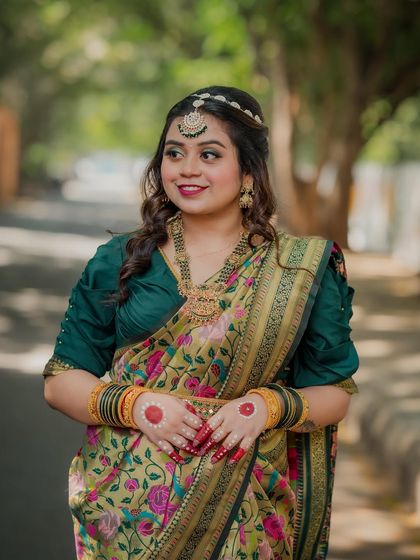 A beautiful three-quarter portrait of the bride, showcasing her elegant pose and the intricate details of her puff-sleeve blouse and traditional jewelry.