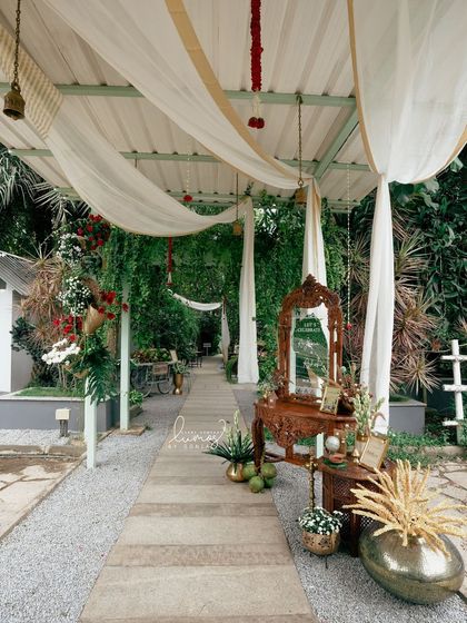 An elegant entrance pathway for an Indo-Western wedding, with flowing drapes and a beautifully carved welcome mirror.