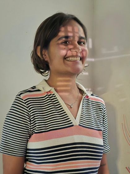 A portrait of Vidya, with light and shadow playing across her face, much like the themes she explored in her own artwork.