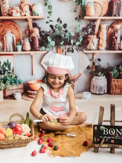 Carefully preparing the strawberries. These themed sessions are wonderful for capturing your child's focus and imagination.