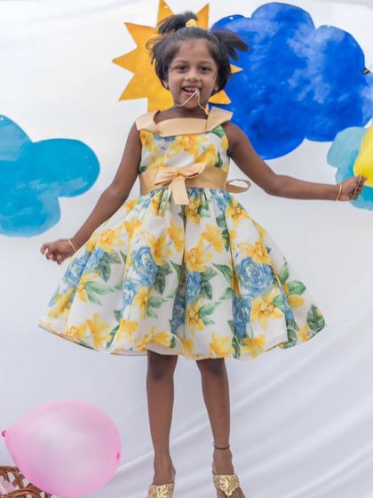 Jumping for joy in a sunny yellow and blue floral dress. This lightweight organza dress is perfect for a garden party or any happy occasion.