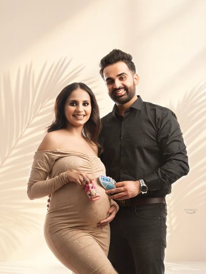 A sweet announcement photo with the couple holding up tiny baby shoes. This is a classic and heartwarming way to share the excitement of expecting, captured in a bright and modern style.