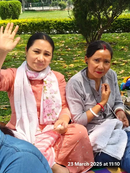 Two women enjoy knitting together at the weekly crafters' meetup in Cubbon Park, a warm and inclusive community we love to support.
