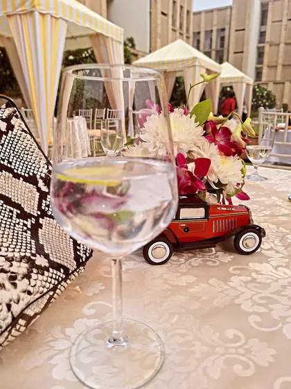 A glass of gin and tonic at The Lodhi's outdoor brunch. The table setting with the miniature red car was a charming detail.