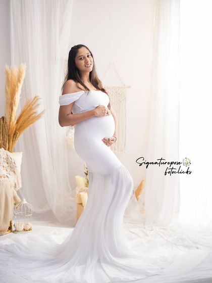 This pose by the window in a white gown creates a soft, angelic look, enhanced by the bright, natural light.