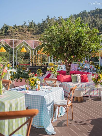 The combination of checkered tablecloths, wooden chairs, and a mountain view perfectly captures the chic picnic vibe.