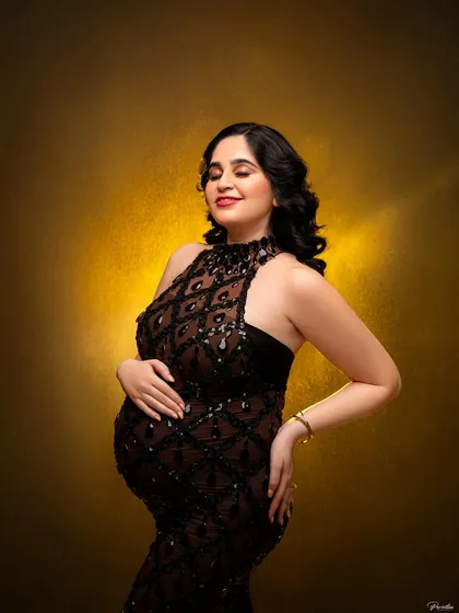 A close-up portrait capturing that beautiful pregnancy glow. The focus here is on the mother's serene expression, highlighted by a glamorous sequined gown and soft lighting that creates a feeling of luxury and warmth.