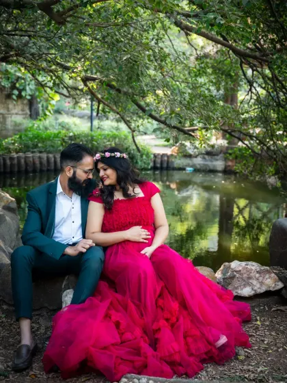 An intimate moment shared by the water's edge. The couple is lost in their own world, surrounded by the peaceful greenery of the park.