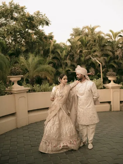 A stylish, full-length portrait of the couple, posed like a magazine editorial against a modern backdrop.