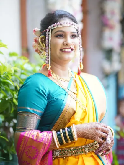 A candid, happy shot of the bride. The natural light highlights her glowing skin and the beautiful colors of her saree.