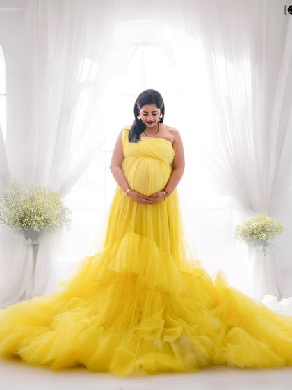 A bright and cheerful portrait celebrating the sunshine you're bringing into the world. This vibrant yellow tulle gown looks stunning against a clean, white backdrop.