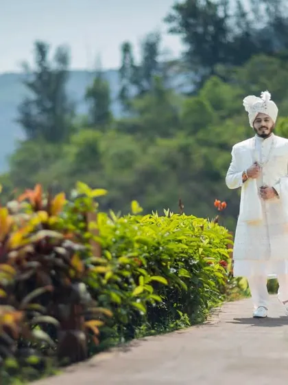 The groom takes a walk through the venue, looking regal in his all-white sherwani.