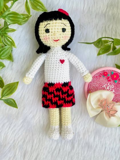 A replica doll of a sweet little girl in a skirt with a red and black pattern. I really enjoyed the challenge of the colorwork on the skirt to make it look just right.