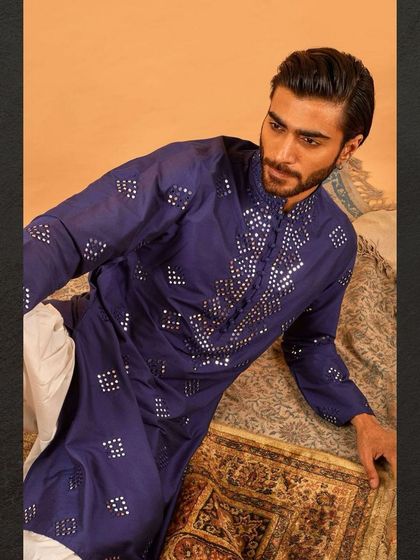 A relaxed pose in our blue mirror work kurta. The light catches the mirrors, creating a subtle sparkle that elevates the entire look.