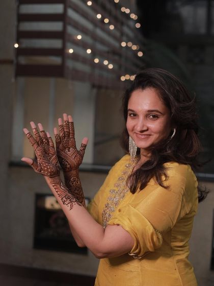 A beautiful portrait of a wedding guest with her party mehendi, ready for the sangeet night.