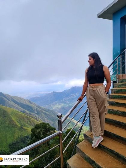 A traveler enjoying the stunning valley views from a viewpoint in Munnar.