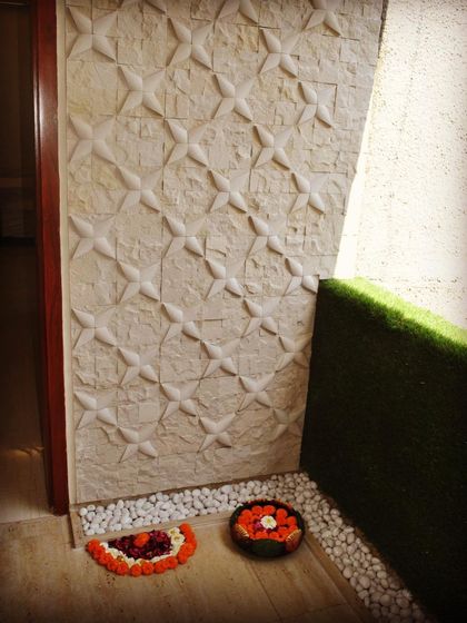 I enhanced this apartment entrance with a 3D stone cladding wall. The textured, star-like pattern adds a touch of luxury and visual interest, complemented by a simple arrangement of pebbles and flowers.