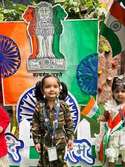 Our youngest students, dressed in tricolor outfits and as national figures, pose proudly in front of a patriotic display, embodying the future of our great nation.