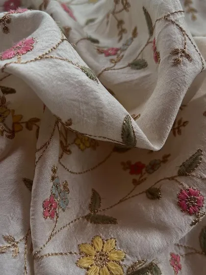 The classic beauty of our off-white embroidered slub silk. The delicate floral embroidery adds a touch of grace, making it perfect for elegant kurtas and suit sets.