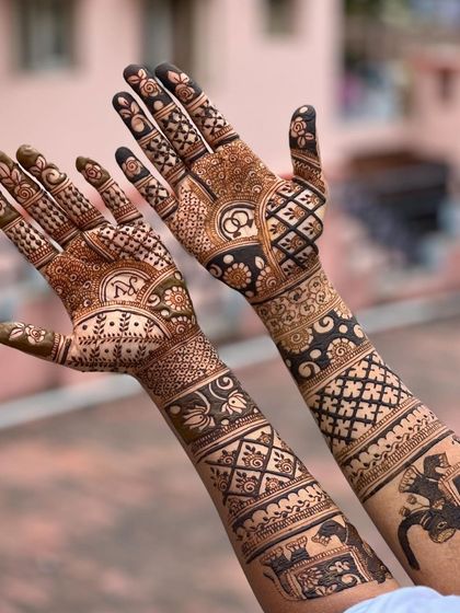 A stunning full-arm engagement mehendi with elephant motifs and intricate check patterns. The design is different on each hand but maintains a cohesive, traditional theme.