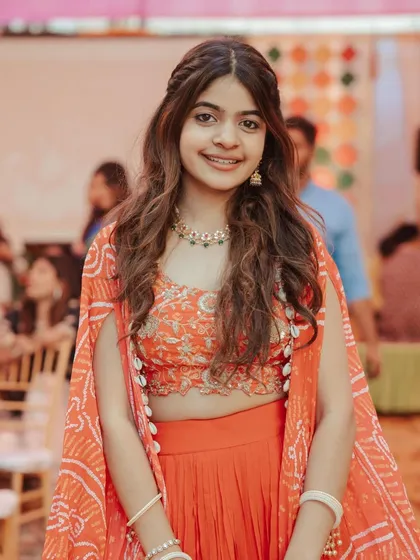 A front view of the bride's sister, her simple hairstyle perfectly complementing her orange outfit.