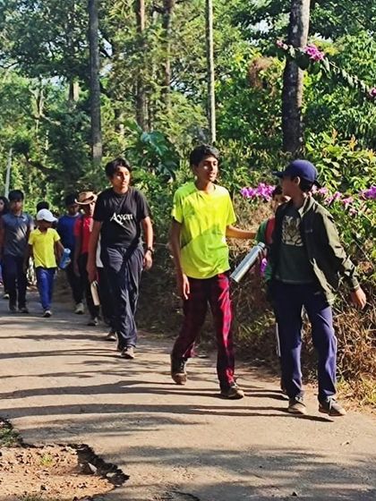 Participants walk along a country road during their trek, taking in the sights and sounds of the Coorg countryside.