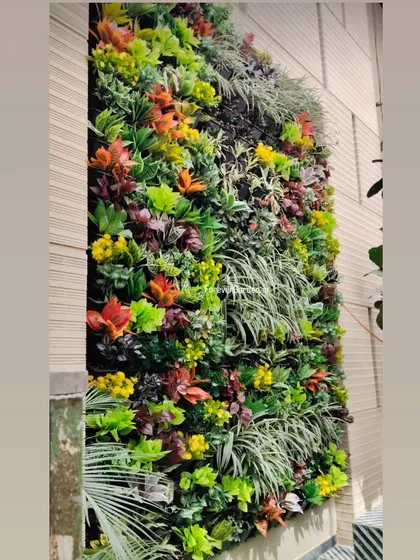 A custom vertical garden featuring a mix of green, red, and yellow artificial plants, adding a burst of color to an exterior wall.