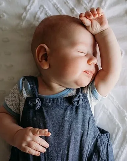 A sweet sleeping pose with the baby's arm resting on their forehead. We patiently wait for these natural poses that show off their personality.