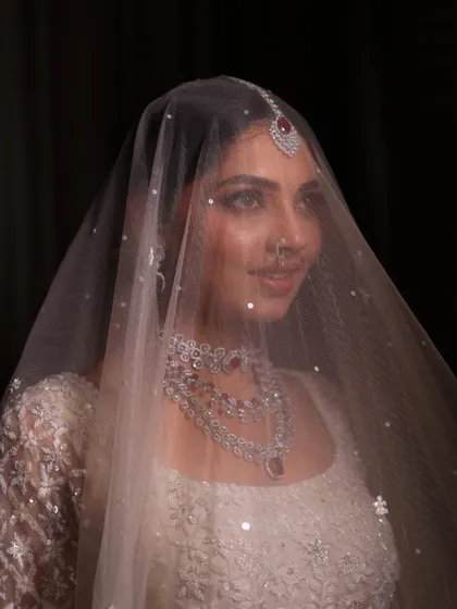 A dreamy shot of the bride under her veil. The soft focus and her serene expression create a truly magical and timeless bridal portrait.