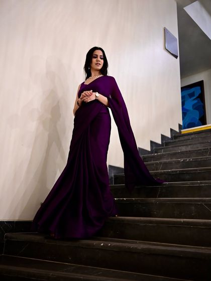 A powerful, full-length shot of the purple saree on a staircase, showcasing its long, flowing pallu.