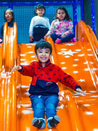 A big smile from a boy as he comes down the slide. The joy on their faces is why we do what we do.