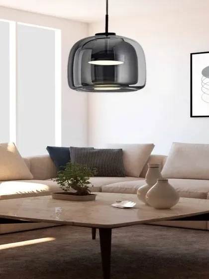 An enticing hanging ceiling light with a smoked glass shade and antique copper finish. This modern pendant is perfect for hanging over a coffee table or in a cozy corner, providing focused, ambient light.