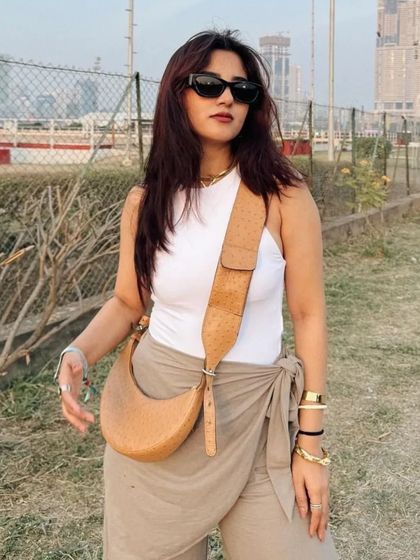 The Selena in Tan Ostrich leather, styled for a sunny day. The unique texture of the ostrich print adds a layer of sophistication to this everyday essential.