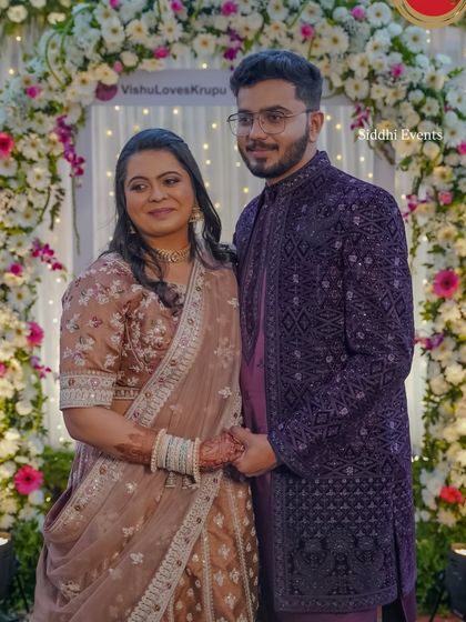 The happy couple posing within the custom floral Instagram frame, a perfect example of how we personalize decor to create lasting memories.