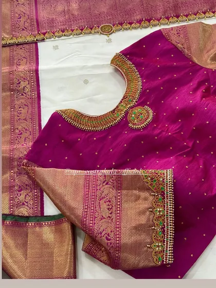 A stunning pink blouse with a heavily embroidered neckline that mimics a traditional temple necklace, paired with a classic white silk saree.
